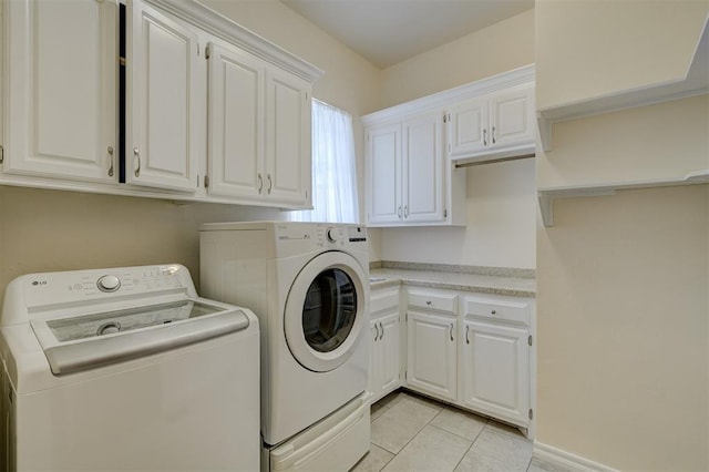 washroom featuring cabinets, light tile patterned floors, and washer and dryer