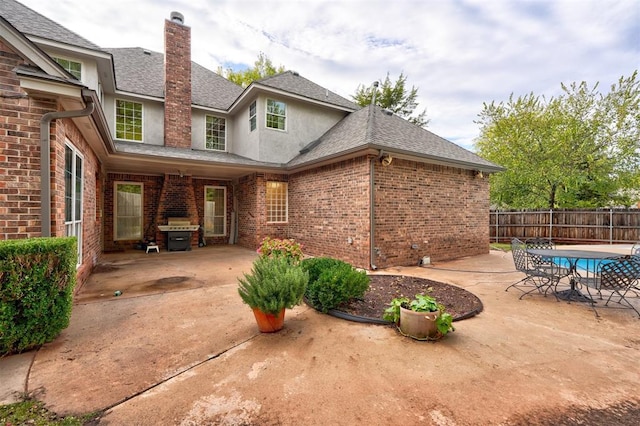 back of property featuring a fenced in pool and a patio area