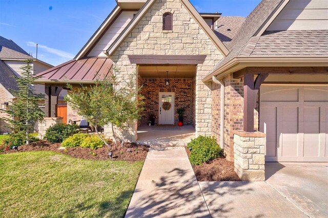 property entrance with a lawn and a garage