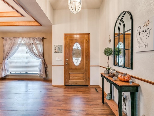 foyer entrance featuring dark hardwood / wood-style floors and an inviting chandelier