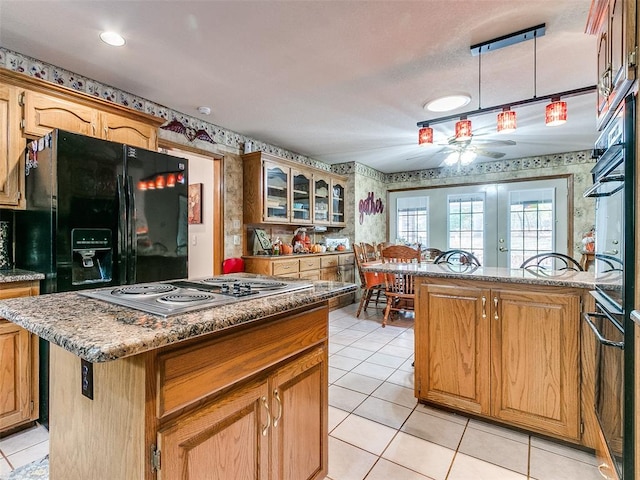 kitchen with light tile patterned flooring, french doors, black appliances, ceiling fan, and a kitchen island