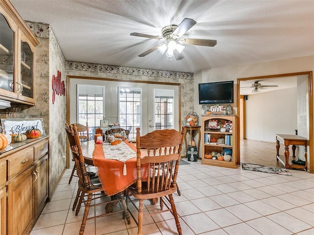 tiled dining area with ceiling fan, french doors, and a textured ceiling