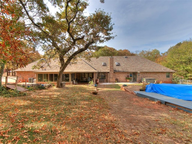 rear view of house with a covered pool