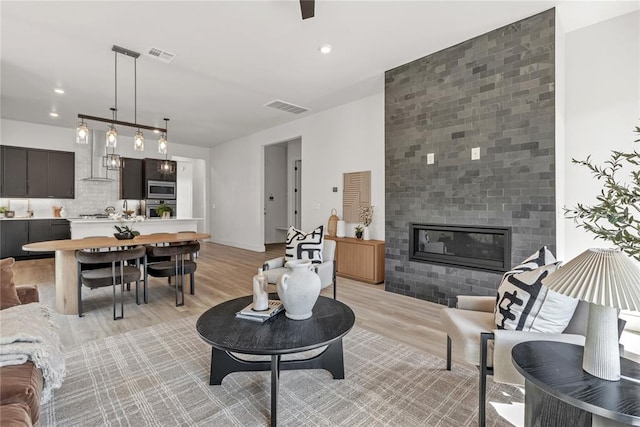 living room with light hardwood / wood-style floors and a tiled fireplace