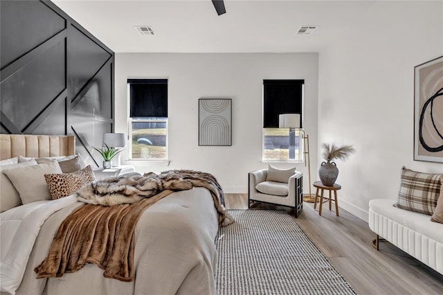 bedroom with multiple windows, ceiling fan, and light hardwood / wood-style floors