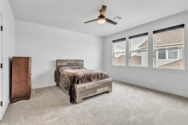 bedroom with ceiling fan and light carpet