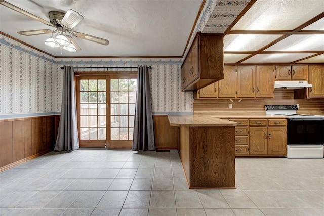 kitchen featuring white range with electric stovetop, kitchen peninsula, ceiling fan, and light tile patterned floors