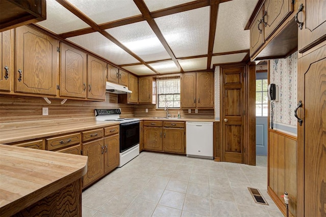 kitchen with backsplash, a textured ceiling, white appliances, sink, and butcher block counters