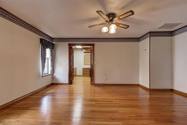 spare room featuring ceiling fan, ornamental molding, and light wood-type flooring