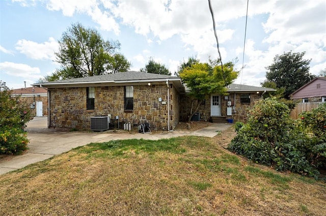 rear view of house with a lawn and central AC unit