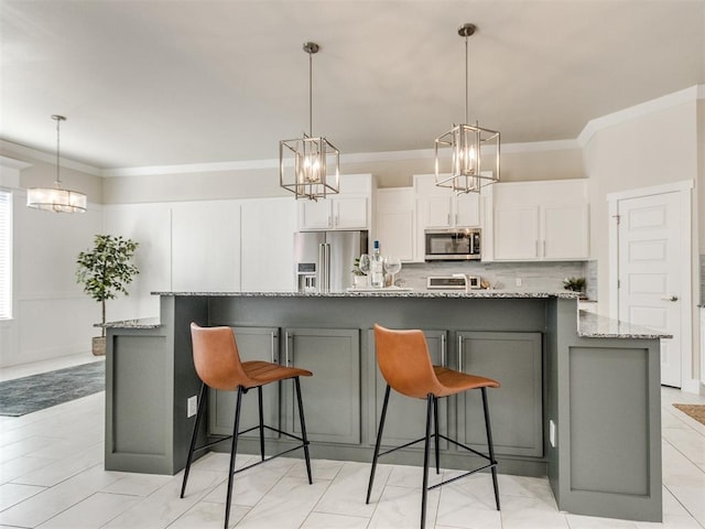 kitchen with appliances with stainless steel finishes, white cabinetry, a spacious island, and light stone countertops