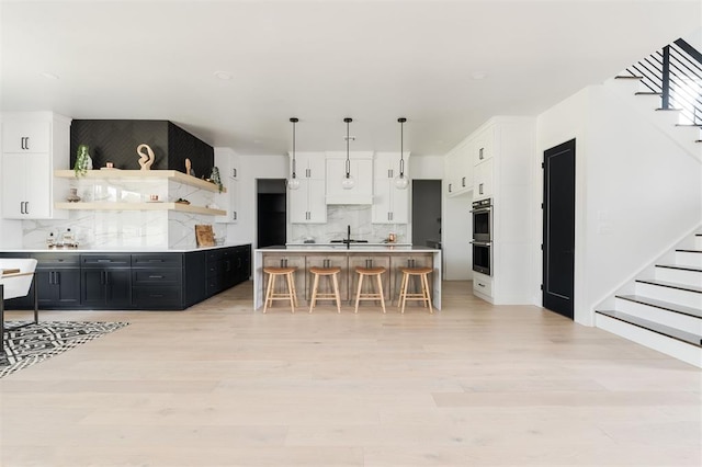 kitchen featuring a kitchen breakfast bar, tasteful backsplash, white cabinets, and a kitchen island