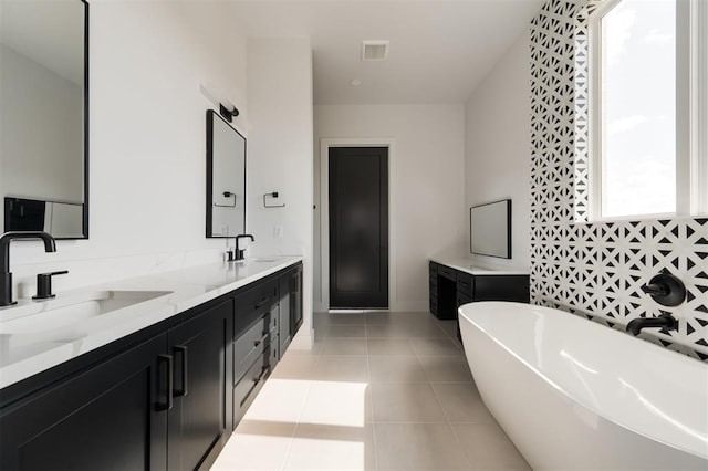 bathroom featuring tile patterned flooring, vanity, and a bathing tub