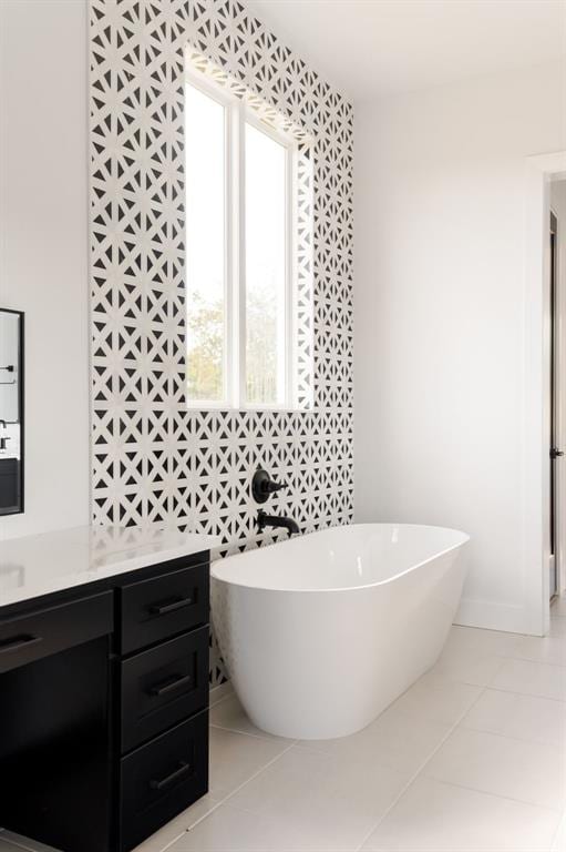 bathroom with tile patterned floors, a bathtub, and tile walls