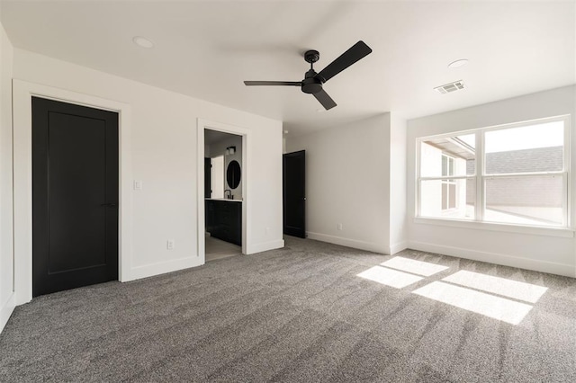 unfurnished bedroom featuring carpet, ensuite bathroom, and ceiling fan