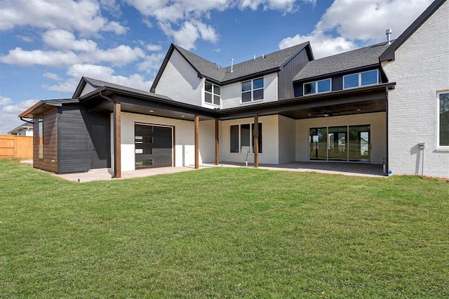 back of property with ceiling fan, a patio area, and a yard