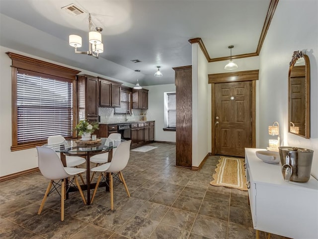 dining room featuring ornamental molding, sink, and a chandelier