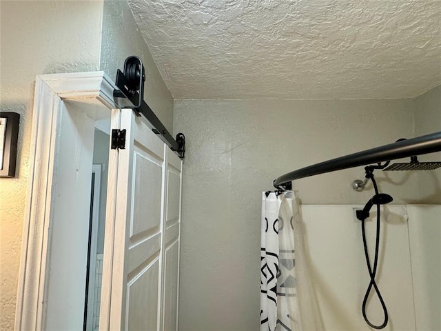 interior details featuring curtained shower and a textured ceiling