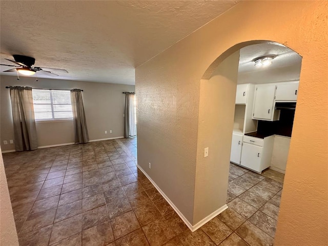 hall with tile patterned flooring and a textured ceiling