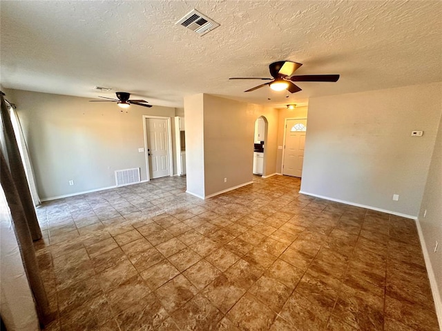 empty room with a textured ceiling and ceiling fan