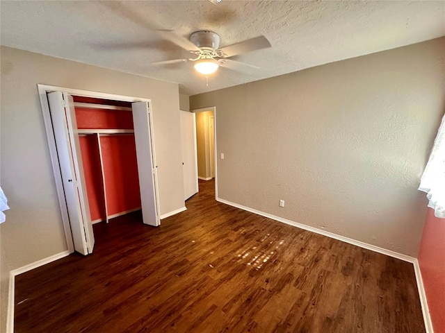 unfurnished bedroom with dark hardwood / wood-style flooring, a closet, and ceiling fan