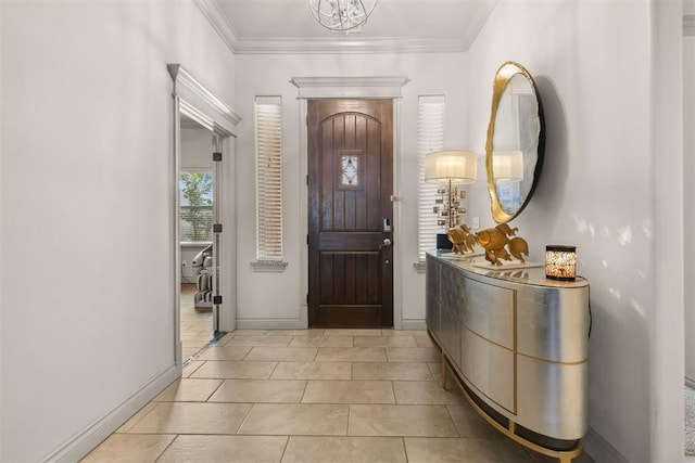 tiled entrance foyer with an inviting chandelier and ornamental molding