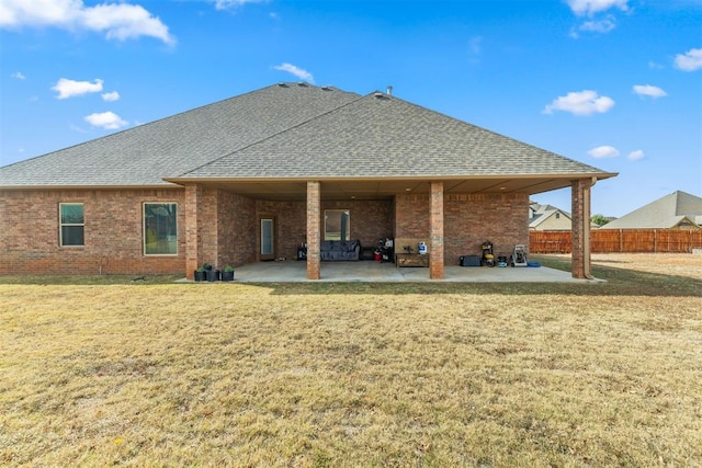 back of house featuring a lawn and a patio area