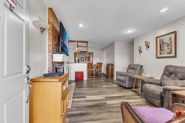 living room with dark hardwood / wood-style flooring and a brick fireplace