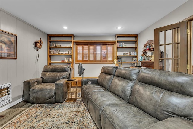 living room featuring hardwood / wood-style flooring, wooden walls, and heating unit