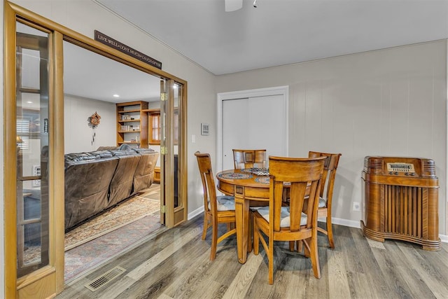 dining area with hardwood / wood-style flooring and crown molding