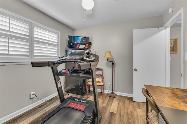 exercise area with light hardwood / wood-style flooring and ceiling fan