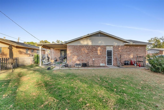 back of property with a patio area and a yard