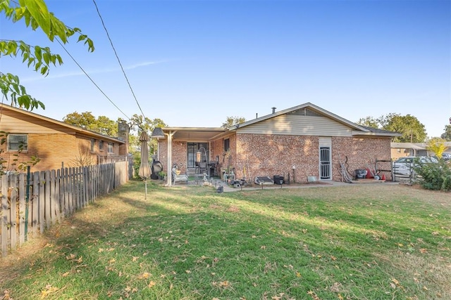 rear view of property featuring a yard and a patio