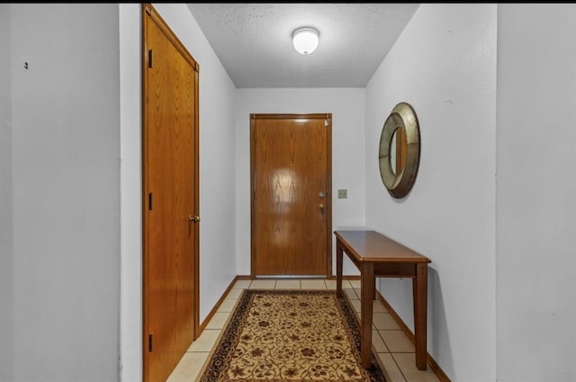 entryway with light tile patterned floors and a textured ceiling