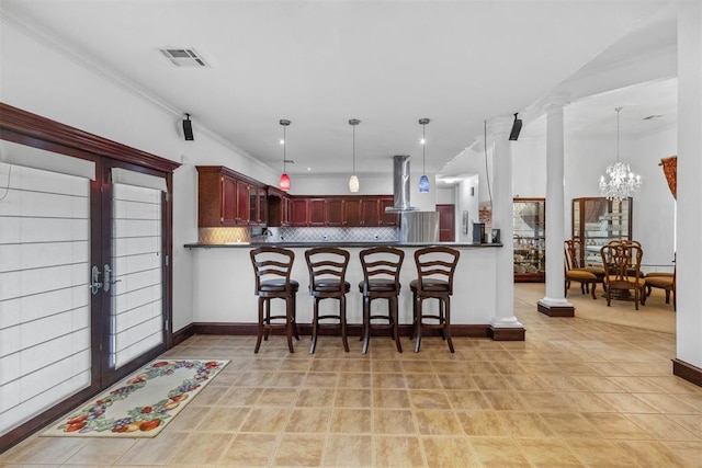 kitchen featuring kitchen peninsula, a chandelier, tasteful backsplash, and hanging light fixtures