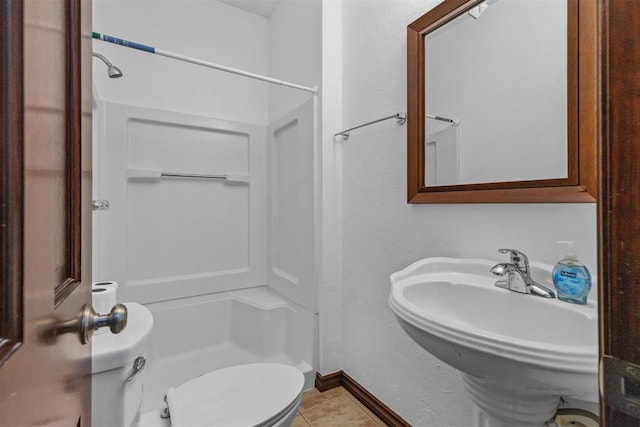 bathroom with tile patterned flooring, toilet, walk in shower, and sink