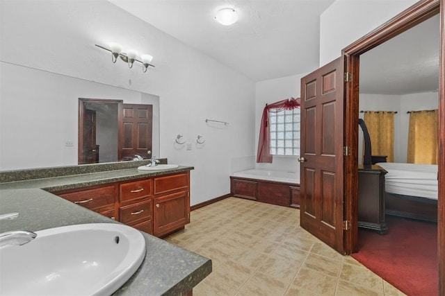 bathroom featuring a tub to relax in, vanity, and lofted ceiling