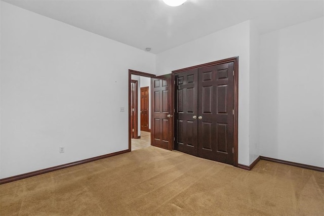 unfurnished bedroom featuring light carpet and a closet