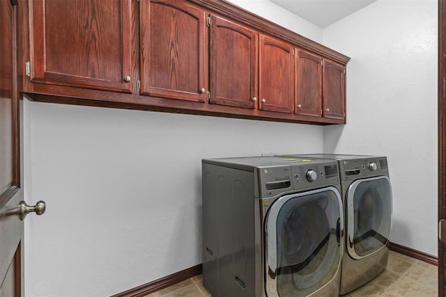 clothes washing area featuring washer and dryer, light tile patterned floors, and cabinets