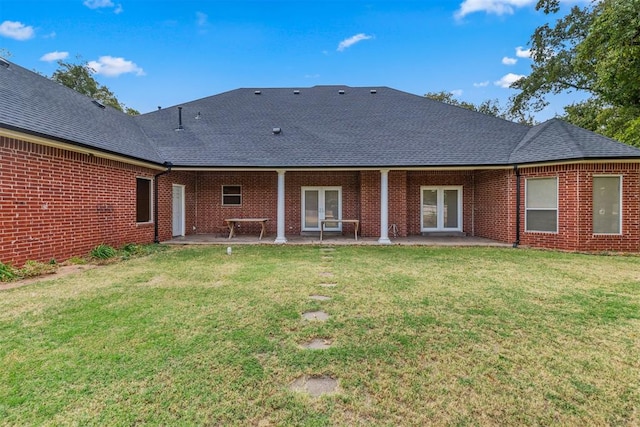 rear view of house with a lawn, a patio, and french doors