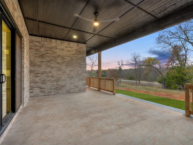 patio terrace at dusk featuring ceiling fan