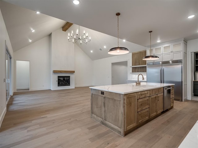 kitchen with sink, a large island with sink, high vaulted ceiling, light hardwood / wood-style flooring, and white cabinetry