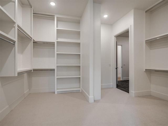 walk in closet featuring light colored carpet