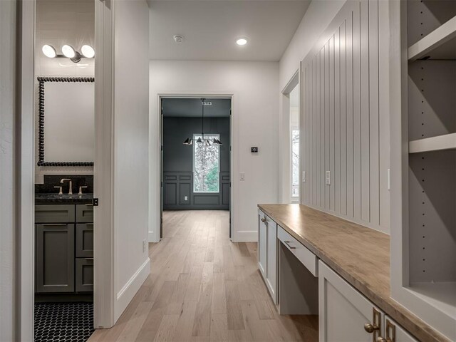 hallway featuring sink and light hardwood / wood-style flooring