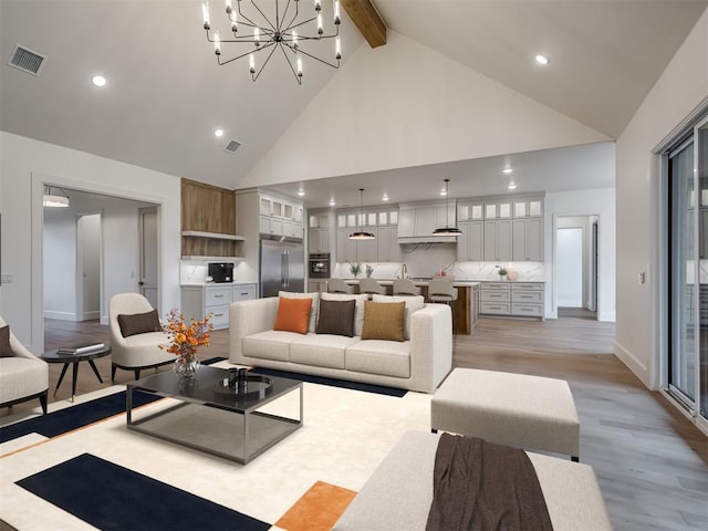 living room with beamed ceiling, light wood-type flooring, high vaulted ceiling, and a chandelier