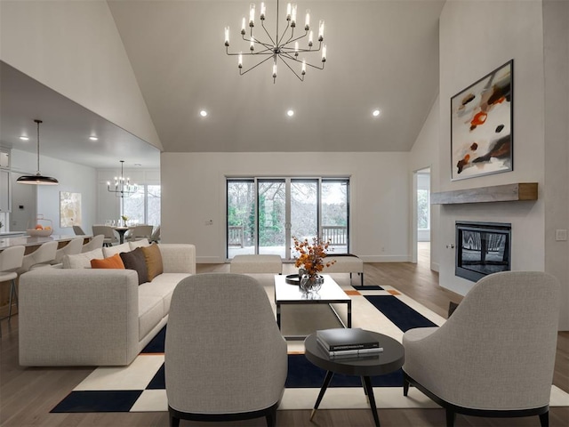 living room with high vaulted ceiling, light hardwood / wood-style floors, and a notable chandelier