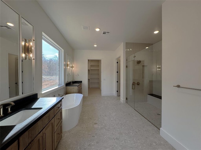 bathroom with vanity and shower with separate bathtub