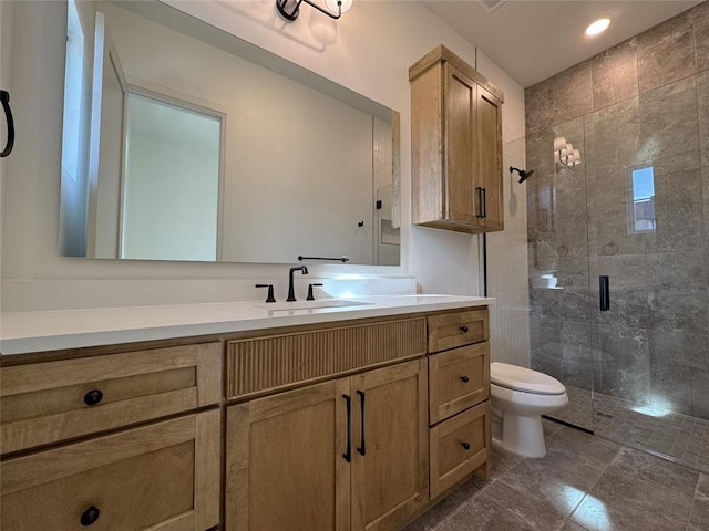 bathroom featuring tile patterned floors, a shower with door, vanity, and toilet