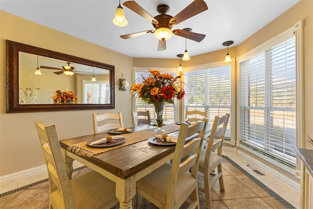 tiled dining space featuring a wealth of natural light and ceiling fan