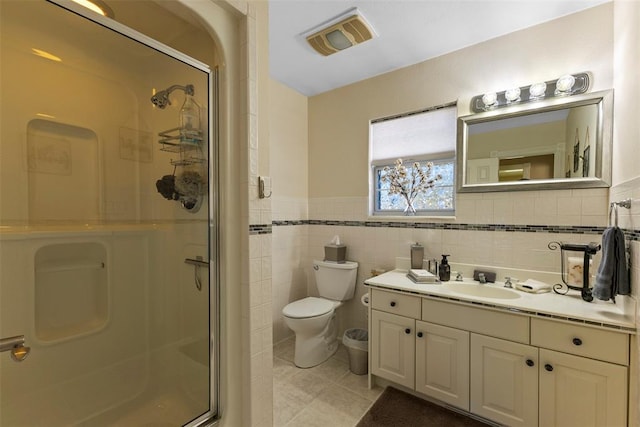 bathroom with toilet, a shower with door, tile patterned floors, and tile walls